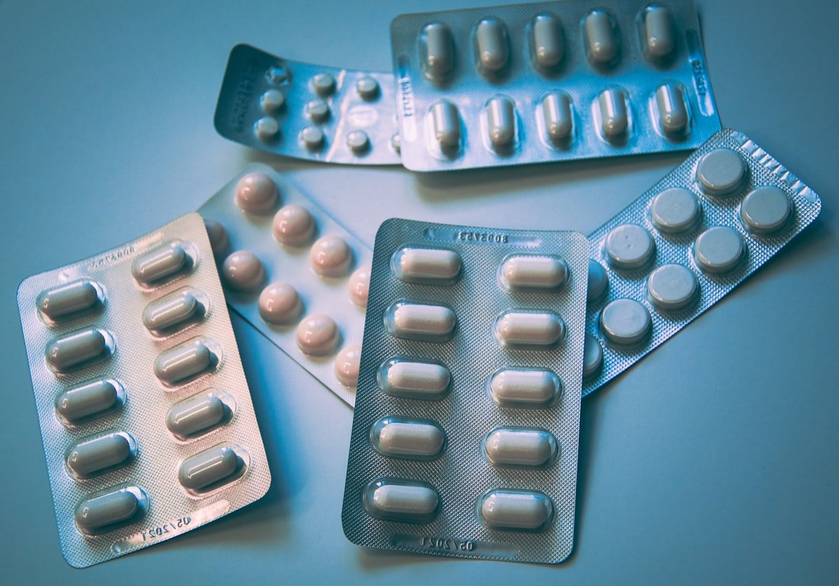 Pharmaceutical pills alongside dried herbs — illustrating the relationship between plant medicine and modern drugs